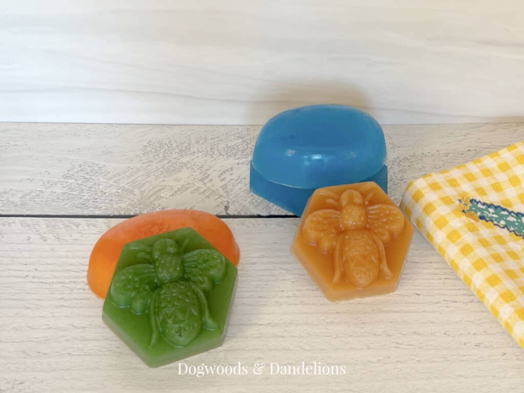 4 assorted melt and pour soaps beside a hand towel.