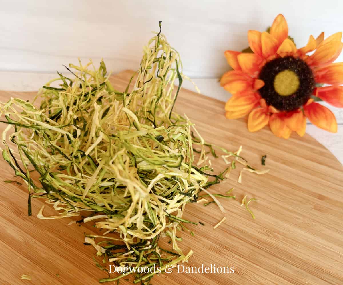 a pile of dried zucchini noodles and a sunflower