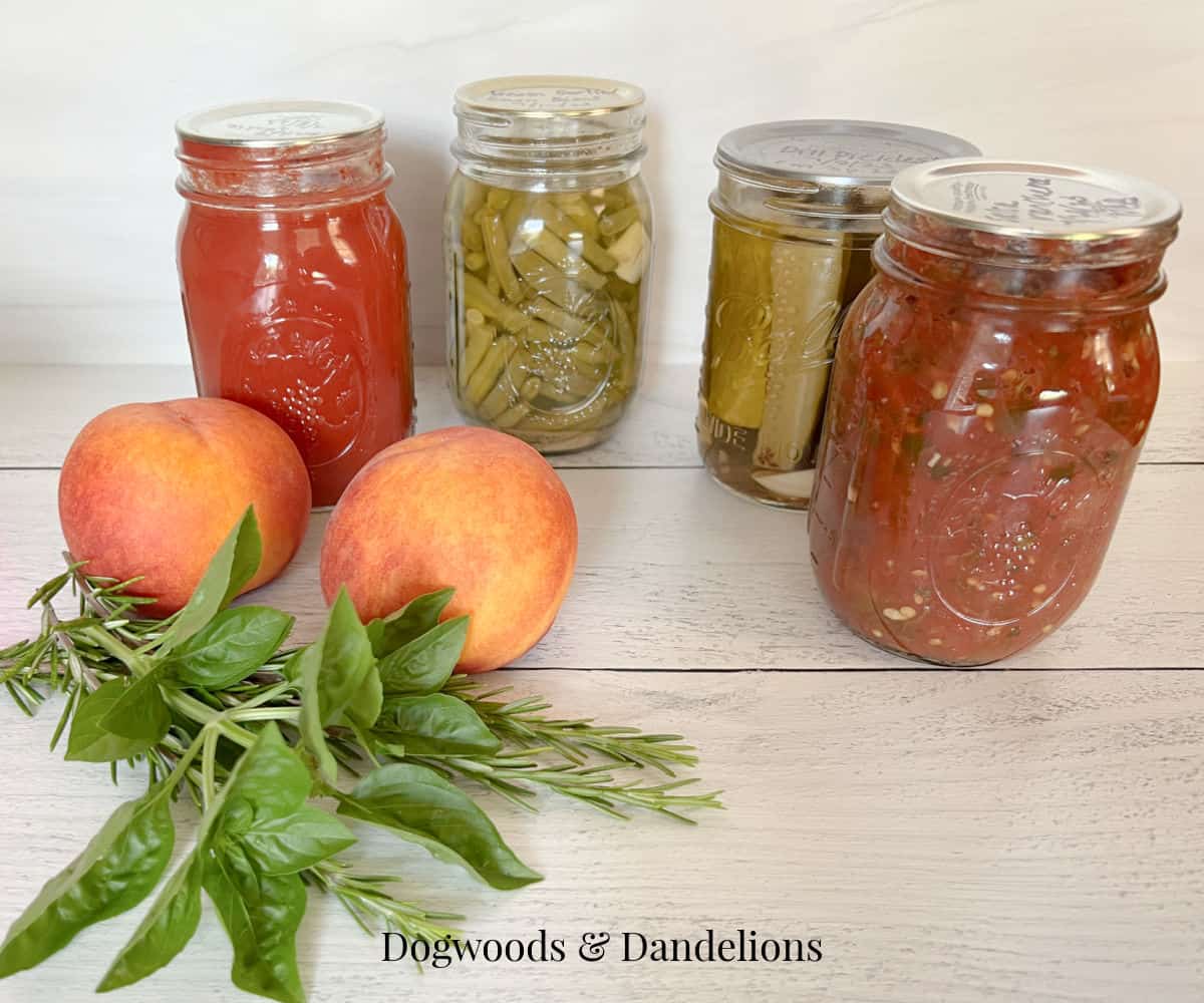 4 jars of home canned goods with peaches and herbs