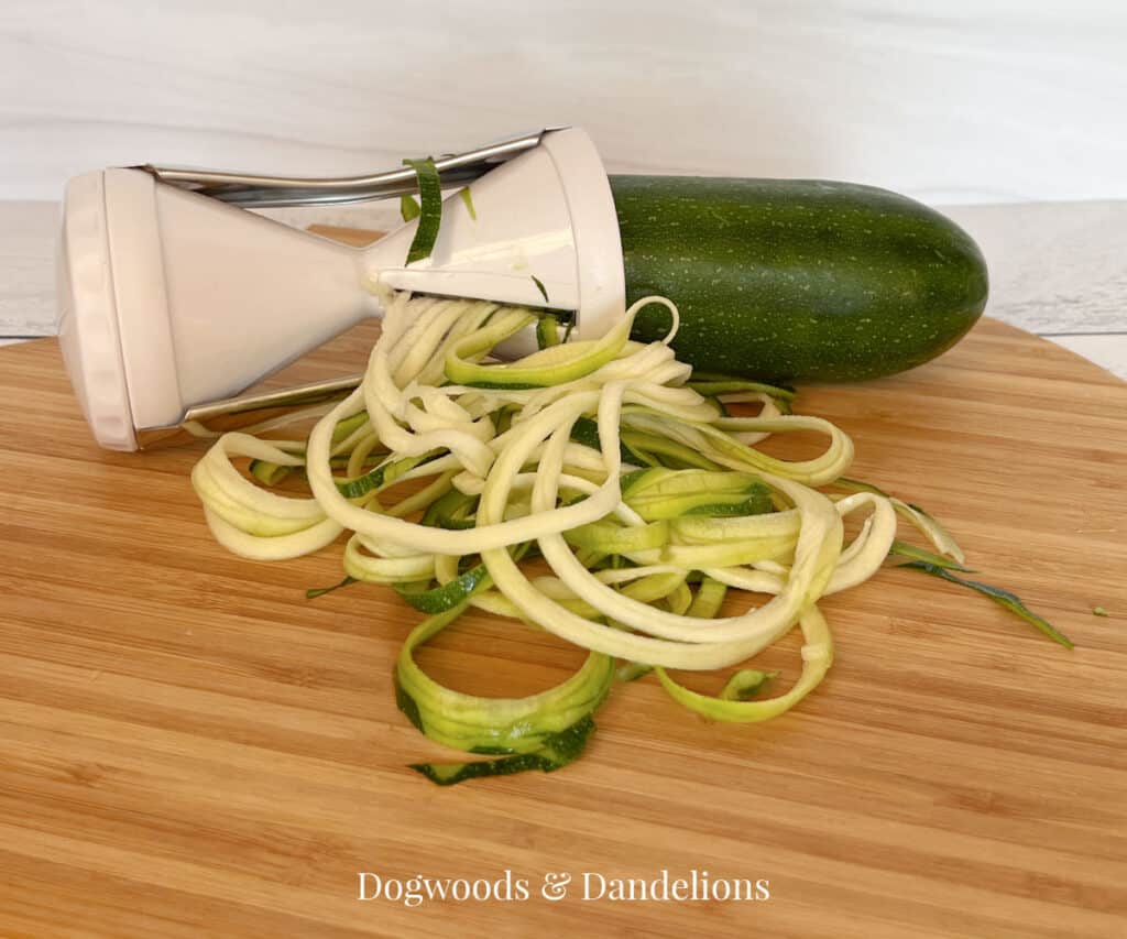 a handheld spiralizer making zucchini noodles