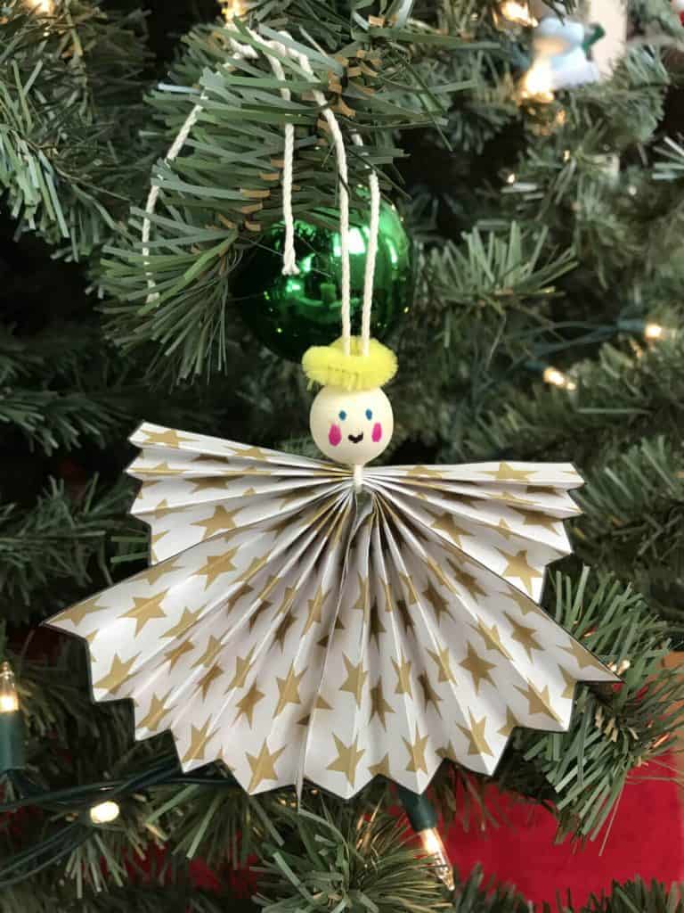 Paper angel ornament hung on a Christmas tree