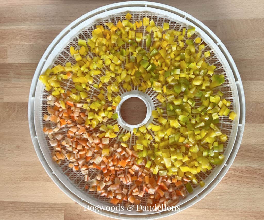 diced peppers on a dehydrator tray before being dehydrated