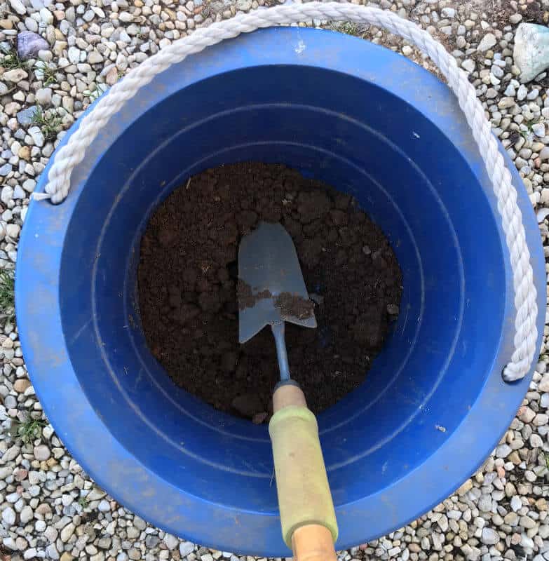 Soil samples being mixed together in a bucket.